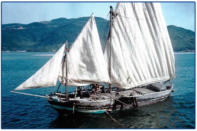 Phu Bai, 1967: Photo of Danang Harbor of a fishing boat under sail. Monkey Mountain can be seen in the background. © 2011 by Ray Cochran