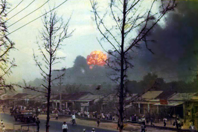 12. Da Nang AB: 366th TFW: Bomb Dump ASP-1 Explosions. Vietnamese civilians near panic, uncertain if the airbase was under attack. Note the foreground trees nearly baren of tree leaves -- Agent Orange effect anyone! April 27, 1968. [Peter Halferty photo]. 