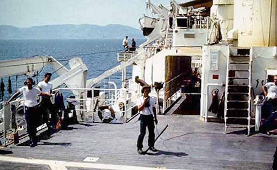 Da Nang Harbor. USS Repose, hospital ship, underway, as deck is cleared and wounded receiving care below. 
